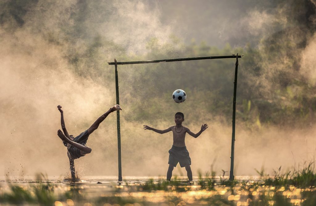 children in misty background playing football